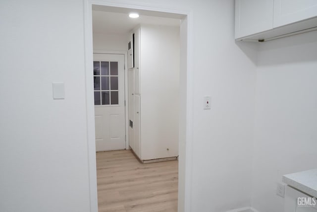 laundry area with light hardwood / wood-style floors