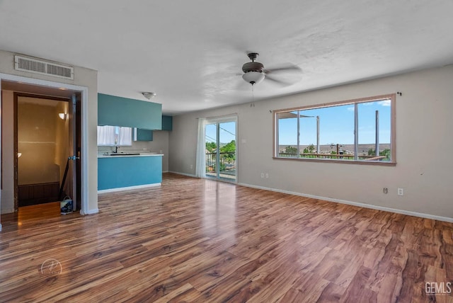 728 D St, Taft, CA 93268 - unfurnished living room featuring dark wood-style floors, baseboards, and ceiling fan