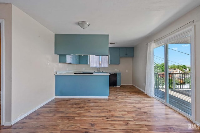 728 D St, Taft, CA 93268 - kitchen featuring a peninsula, wood finished floors, baseboards, light countertops, and black dishwasher