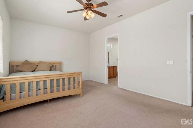 carpeted bedroom featuring ensuite bath, visible vents, baseboards, and a ceiling fan