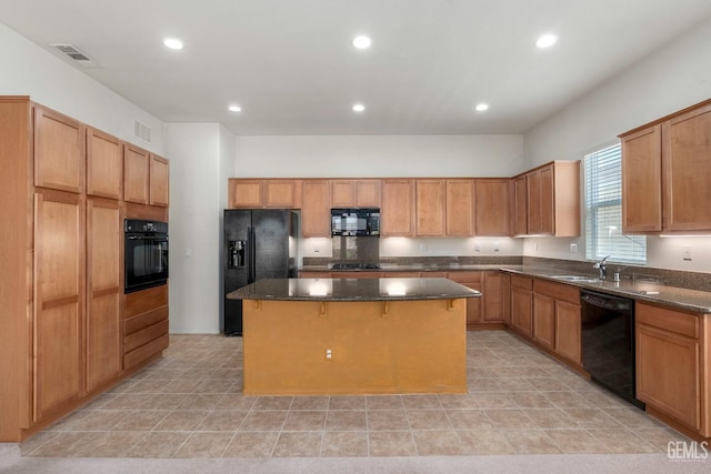 kitchen with a center island, visible vents, black appliances, and a sink