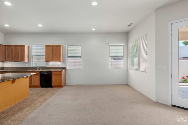 kitchen with dishwasher, a wealth of natural light, visible vents, and dark countertops