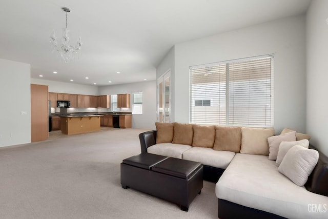 living area featuring light colored carpet, a notable chandelier, and recessed lighting