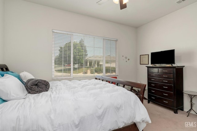 bedroom featuring a ceiling fan, multiple windows, light carpet, and visible vents