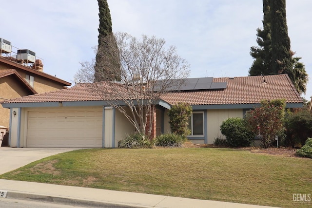 view of front facade with an attached garage, solar panels, a front yard, and a tile roof