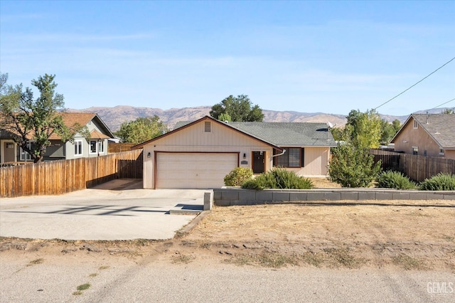 ranch-style home with a garage and a mountain view