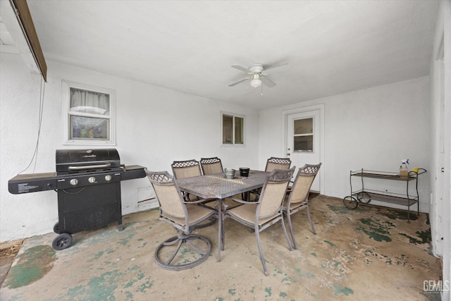 dining space featuring concrete flooring and ceiling fan