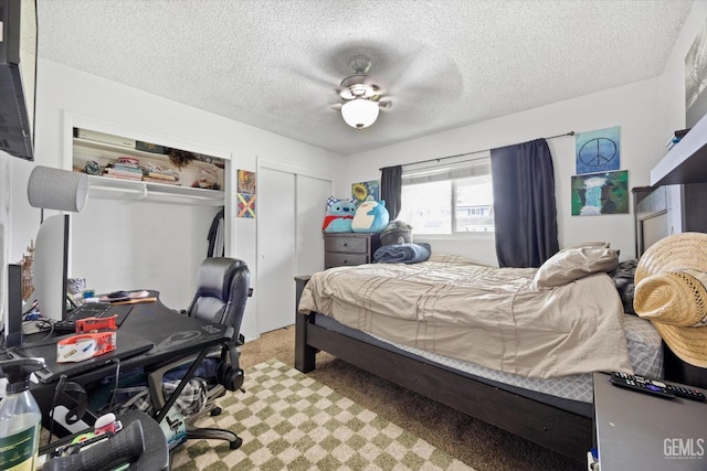 bedroom featuring a textured ceiling, ceiling fan, carpet flooring, and two closets