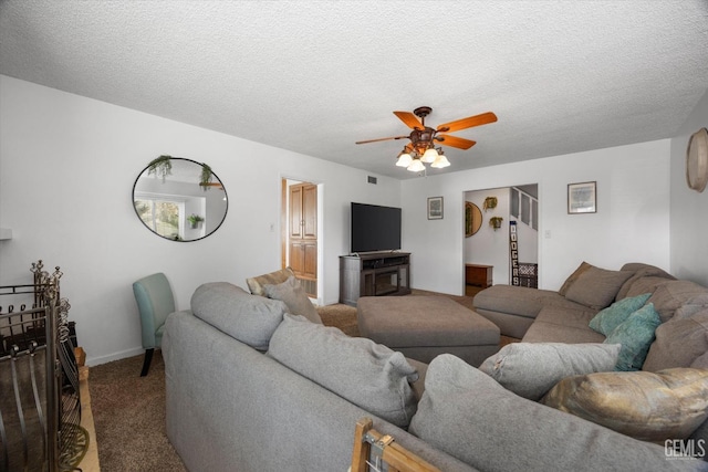 living area featuring a textured ceiling, ceiling fan, and carpet flooring