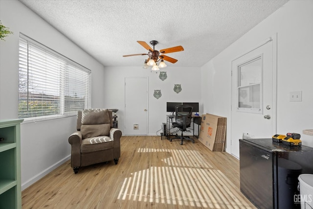 office space with ceiling fan, a textured ceiling, and light wood finished floors