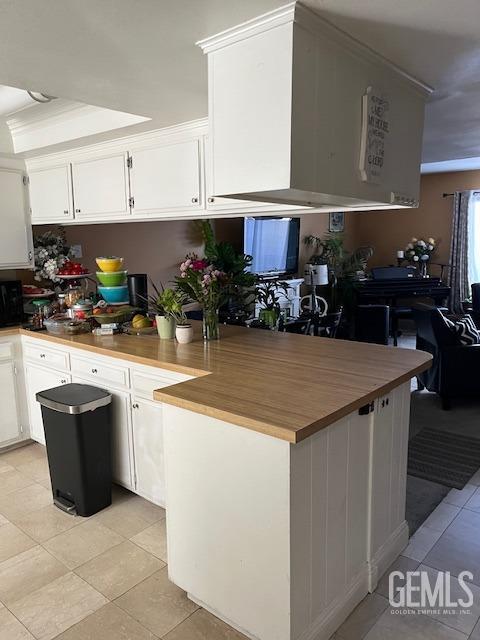 2626 E Cleo Ct Unit 29, Bakersfield, CA 93306 - kitchen featuring light tile patterned floors, white cabinets, and a peninsula