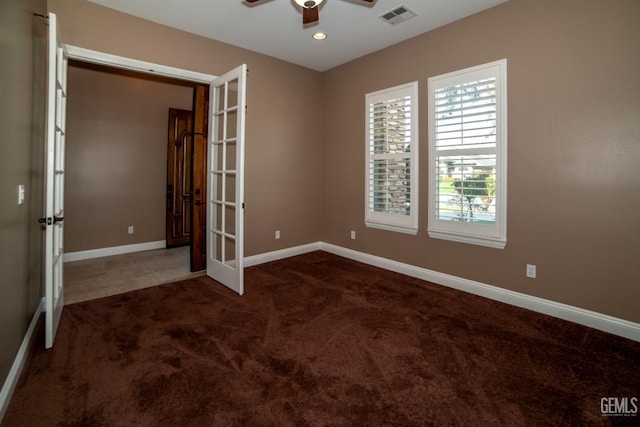 empty room with french doors, ceiling fan, and dark colored carpet