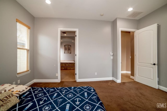 unfurnished bedroom featuring ensuite bath and dark carpet