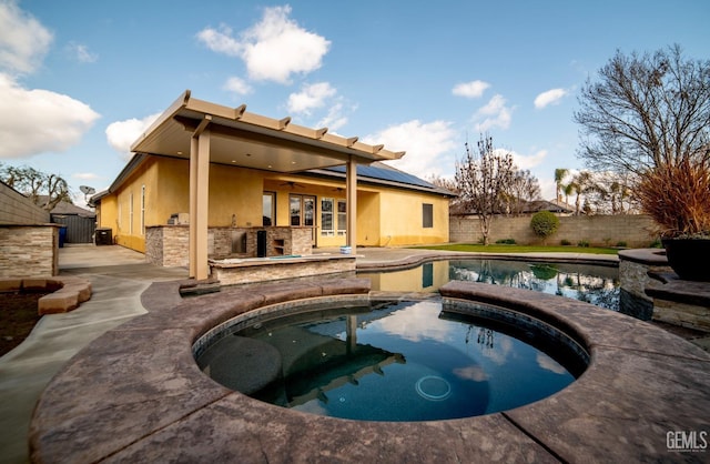 view of swimming pool featuring a patio area, an in ground hot tub, ceiling fan, and exterior kitchen