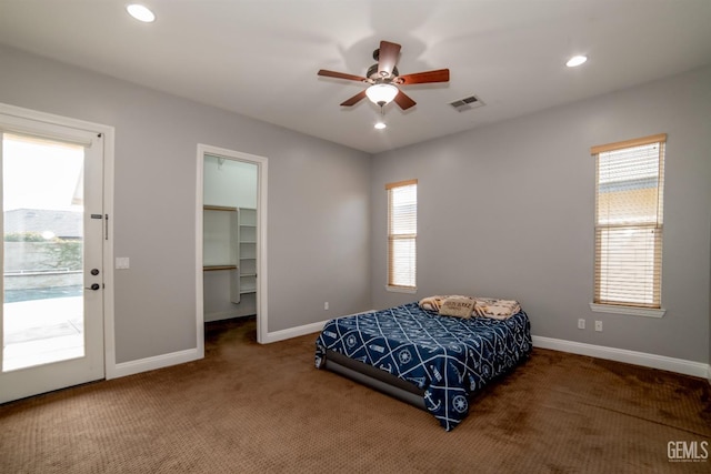 carpeted bedroom with ceiling fan, a walk in closet, a closet, and access to outside