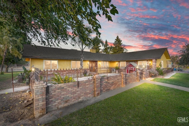 ranch-style home featuring a lawn