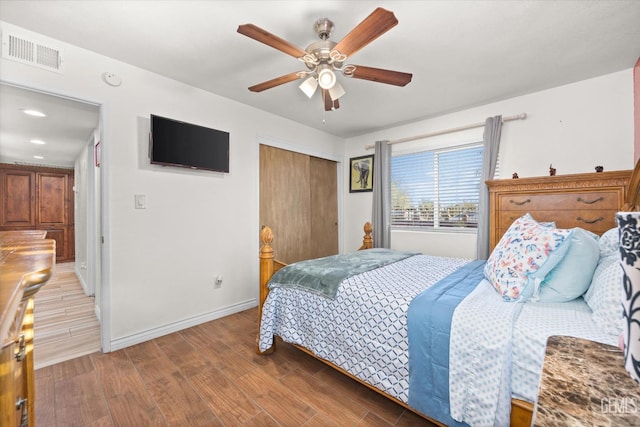 bedroom with ceiling fan, wood-type flooring, and a closet