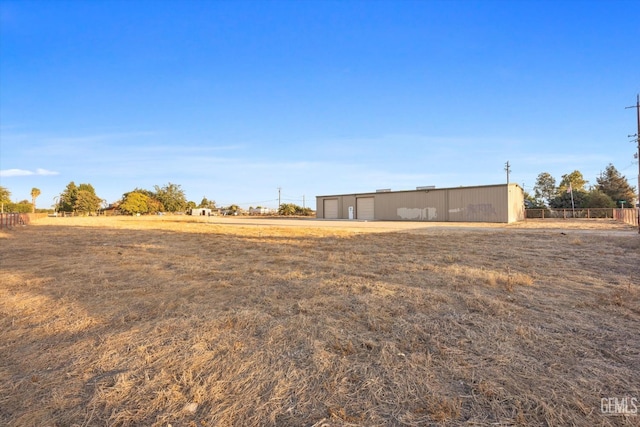 view of yard featuring a rural view and an outdoor structure