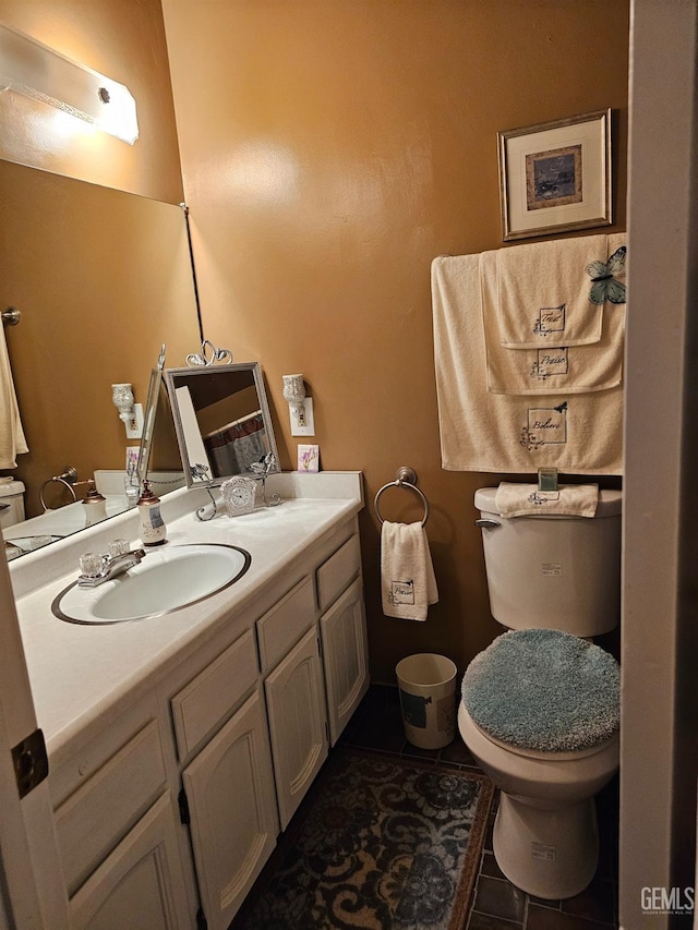 bathroom with toilet, vanity, and tile patterned floors