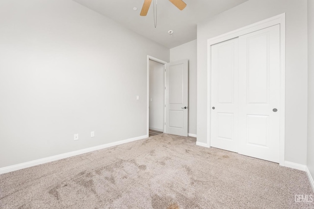 unfurnished bedroom with a closet, baseboards, ceiling fan, and carpet flooring