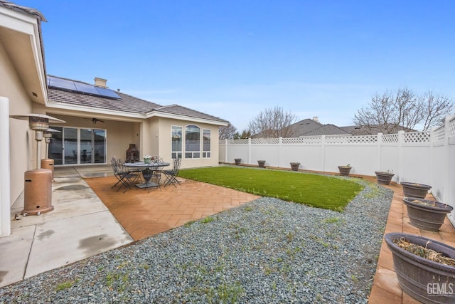 view of yard featuring a fenced backyard, a ceiling fan, and a patio