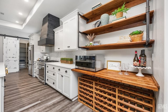 kitchen with white cabinetry, open shelves, light countertops, and premium appliances