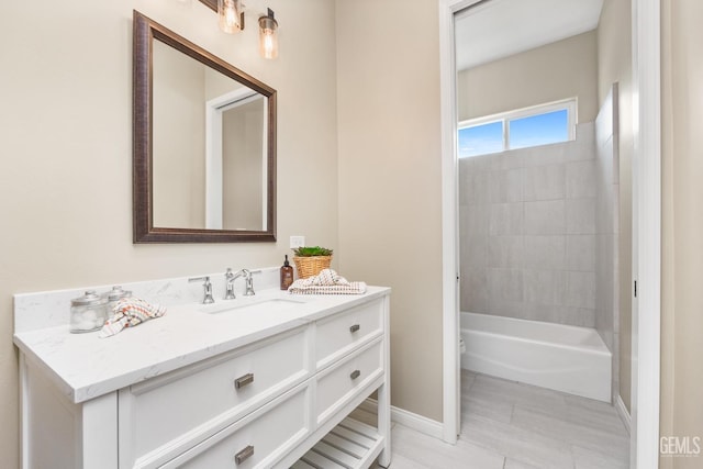 bathroom featuring tub / shower combination, vanity, and baseboards