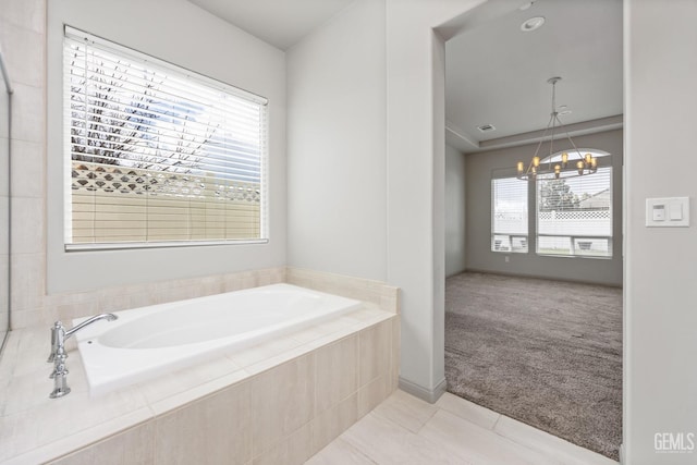 bathroom featuring tile patterned flooring, a notable chandelier, visible vents, and a garden tub