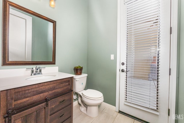 half bathroom with vanity, toilet, baseboards, and tile patterned flooring