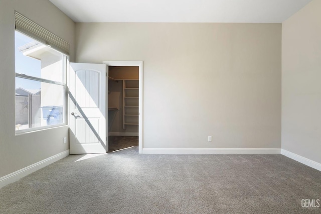 unfurnished room featuring baseboards, carpet floors, and a healthy amount of sunlight