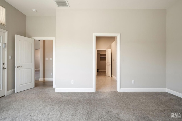 unfurnished bedroom featuring carpet, visible vents, and baseboards