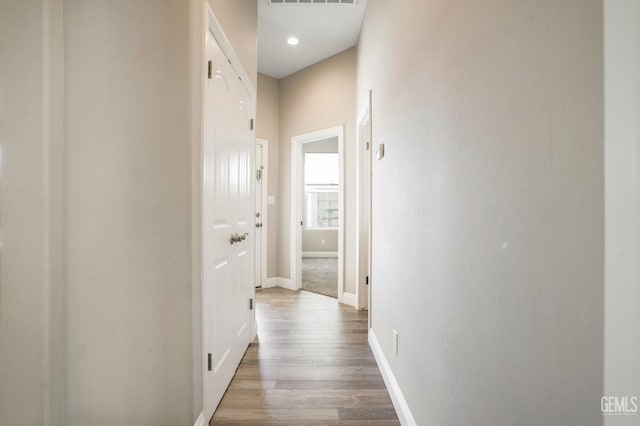 hallway featuring visible vents, recessed lighting, baseboards, and wood finished floors