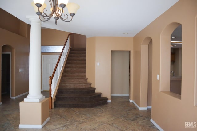 stairway with a chandelier, baseboards, and decorative columns