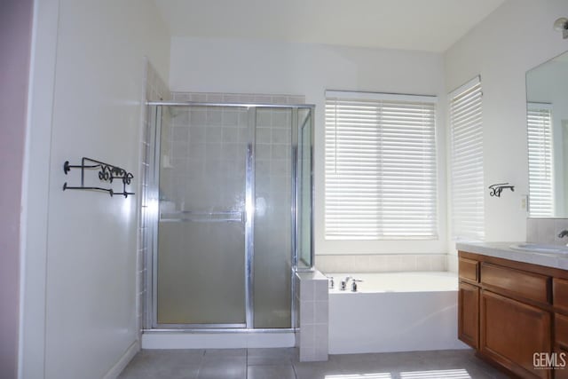 full bathroom featuring a garden tub, a healthy amount of sunlight, a stall shower, and vanity