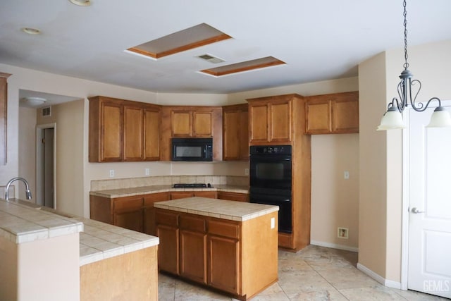 kitchen featuring black appliances, tile countertops, brown cabinetry, and visible vents