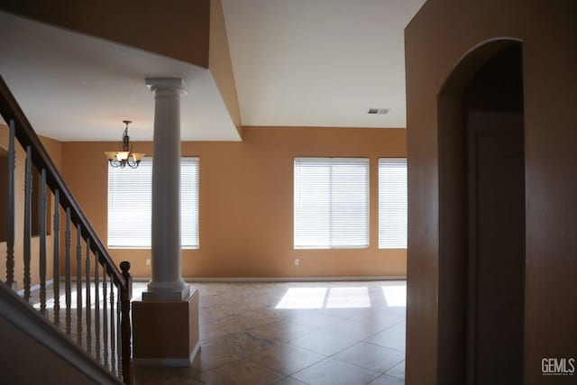 interior space featuring a wealth of natural light, visible vents, a notable chandelier, and ornate columns