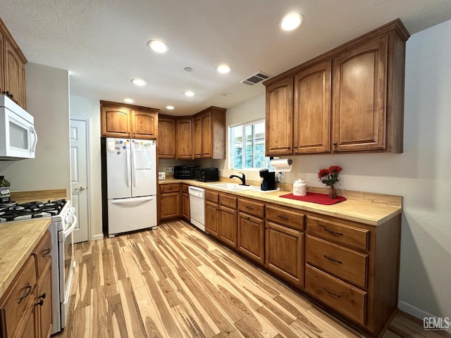 45796 Rocking K Dr, Cal Hot Springs, CA 93207 - kitchen featuring white appliances, a sink, light wood-style flooring, brown cabinets, and light countertops