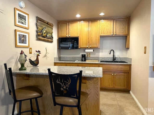 45796 Rocking K Dr, Cal Hot Springs, CA 93207 - kitchen featuring black microwave, a sink, a kitchen breakfast bar, light stone countertops, and recessed lighting