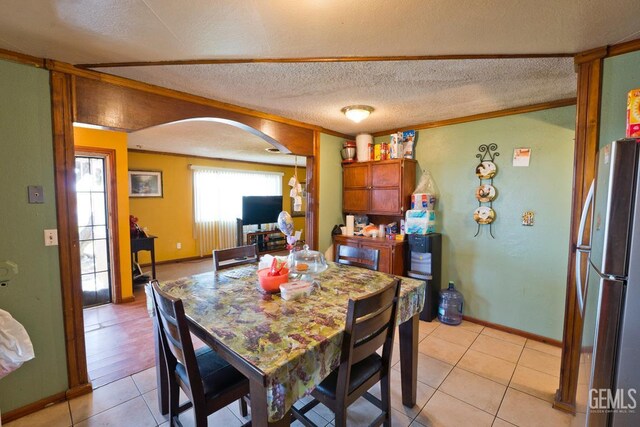 18695 Beech Ave, Shafter, CA 93263 - dining space featuring light tile patterned floors, a textured ceiling, baseboards, and arched walkways