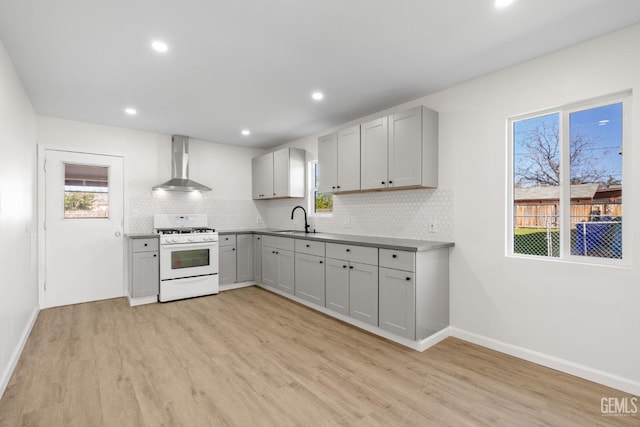 409 Jane St, Bakersfield, CA 93306 - kitchen featuring light wood-type flooring, decorative backsplash, a sink, wall chimney range hood, and white gas range oven