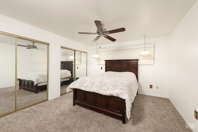 bedroom featuring carpet floors, two closets, and ceiling fan