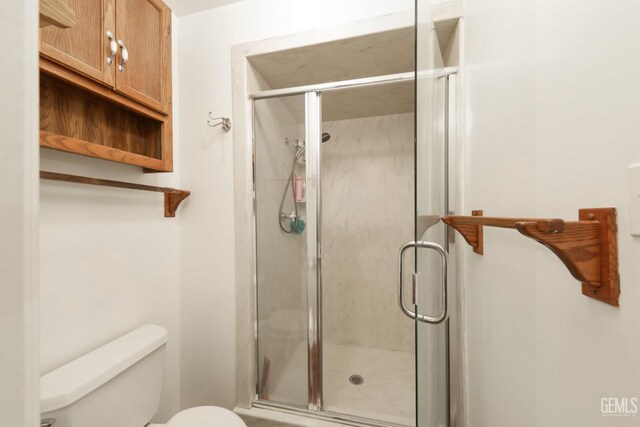 bathroom with an enclosed shower and toilet