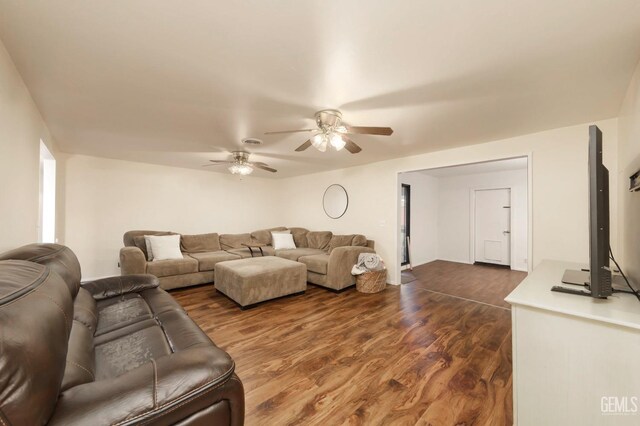 living room featuring ceiling fan and dark hardwood / wood-style flooring