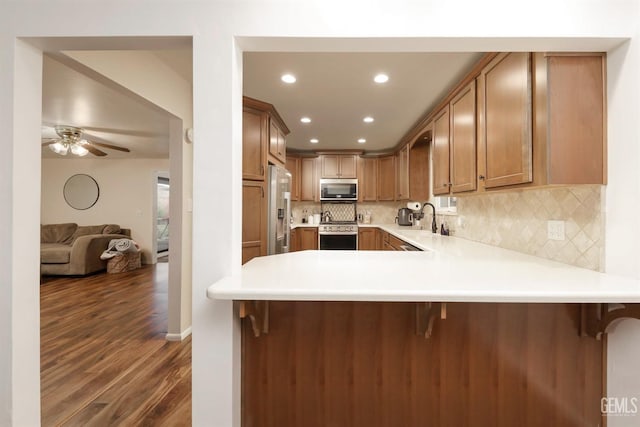 kitchen featuring a kitchen breakfast bar, kitchen peninsula, and stainless steel appliances