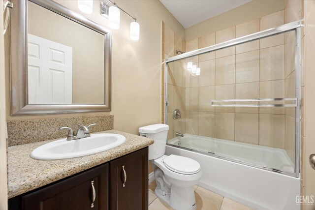 full bathroom with tile patterned flooring, vanity, toilet, and bath / shower combo with glass door