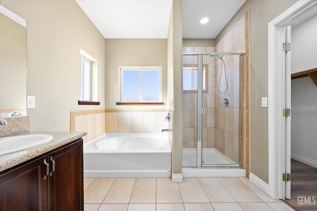 bathroom with tile patterned floors, vanity, and shower with separate bathtub