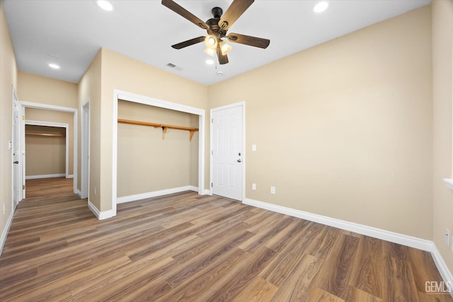 unfurnished bedroom featuring ceiling fan, dark wood-type flooring, and a closet