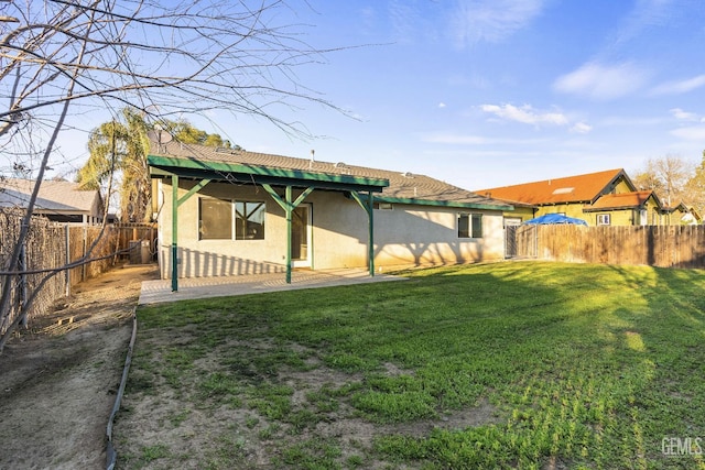 back of property with a patio, a lawn, a fenced backyard, and stucco siding