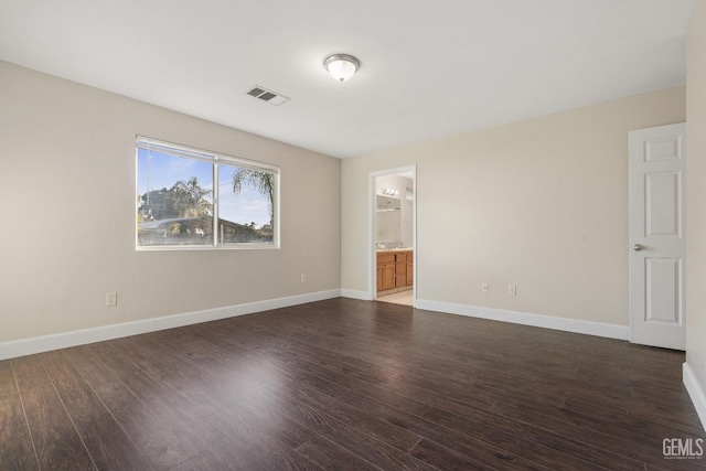 unfurnished room with visible vents, baseboards, and wood finished floors