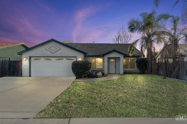 single story home featuring a yard, stucco siding, an attached garage, fence, and driveway